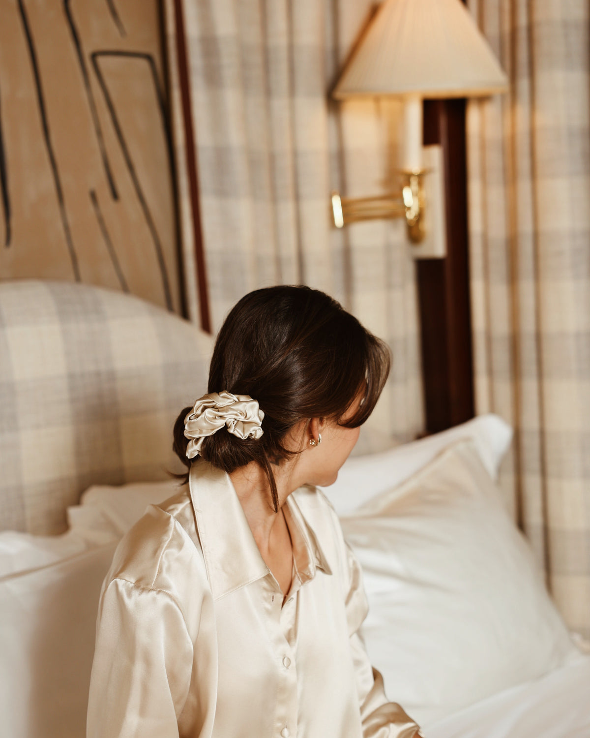 Champagne silk scrunchie low bun sitting in bed back view
