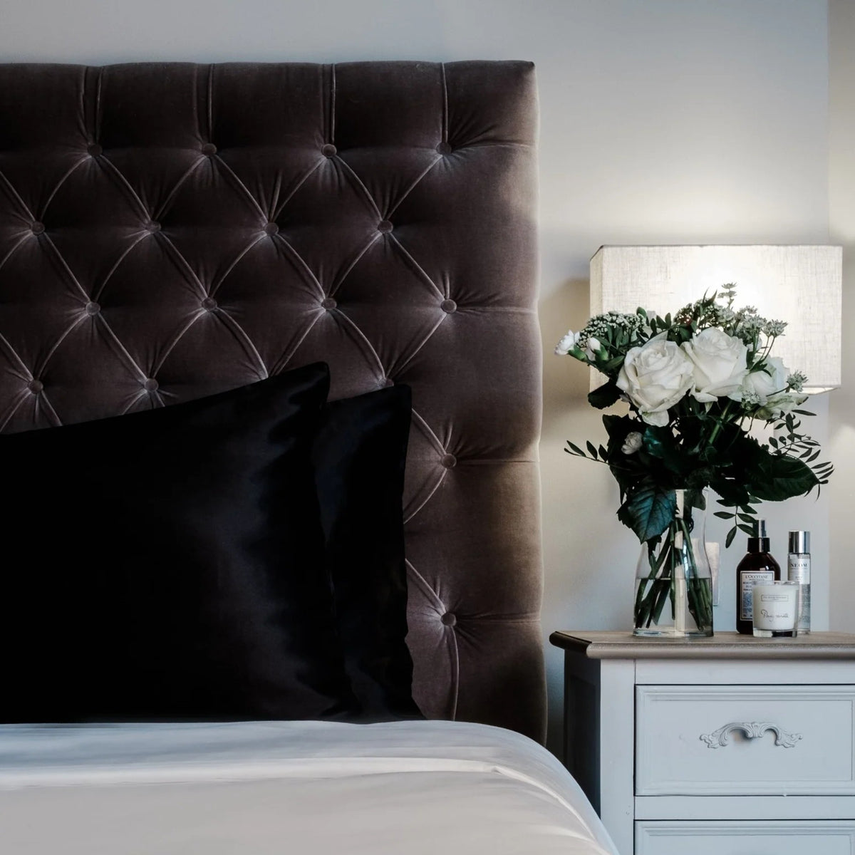 Eclipse Black mulberry silk pillowcase on a velvet headboard