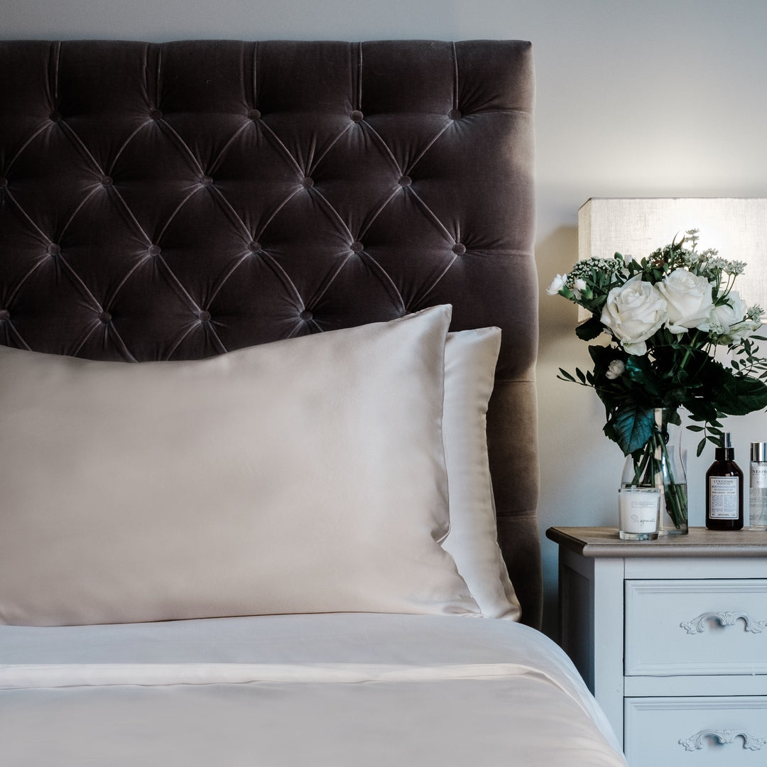 Champagne king size mulberry silk pillowcase for hair and skin, 22 momme 100% silk, on a velvet headboard | The Silk Collection
