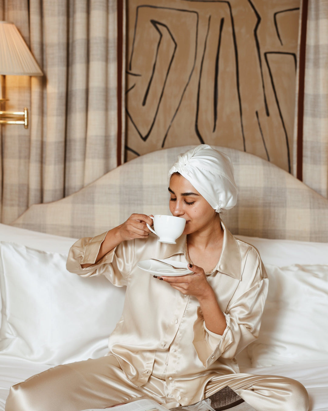 Pearl white silk bonnet sipping tea in bed
