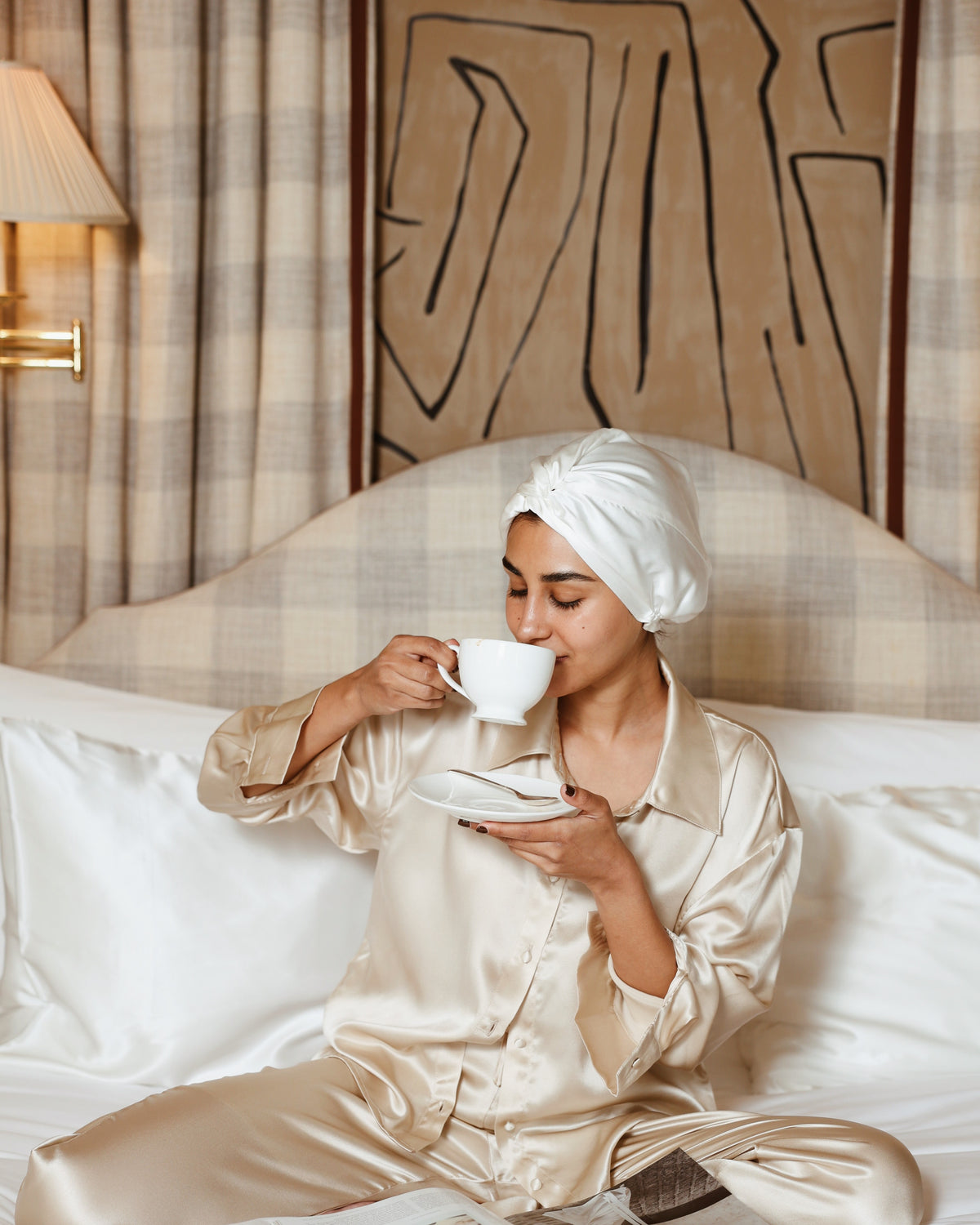 Pearl white silk bonnet sipping tea in bed