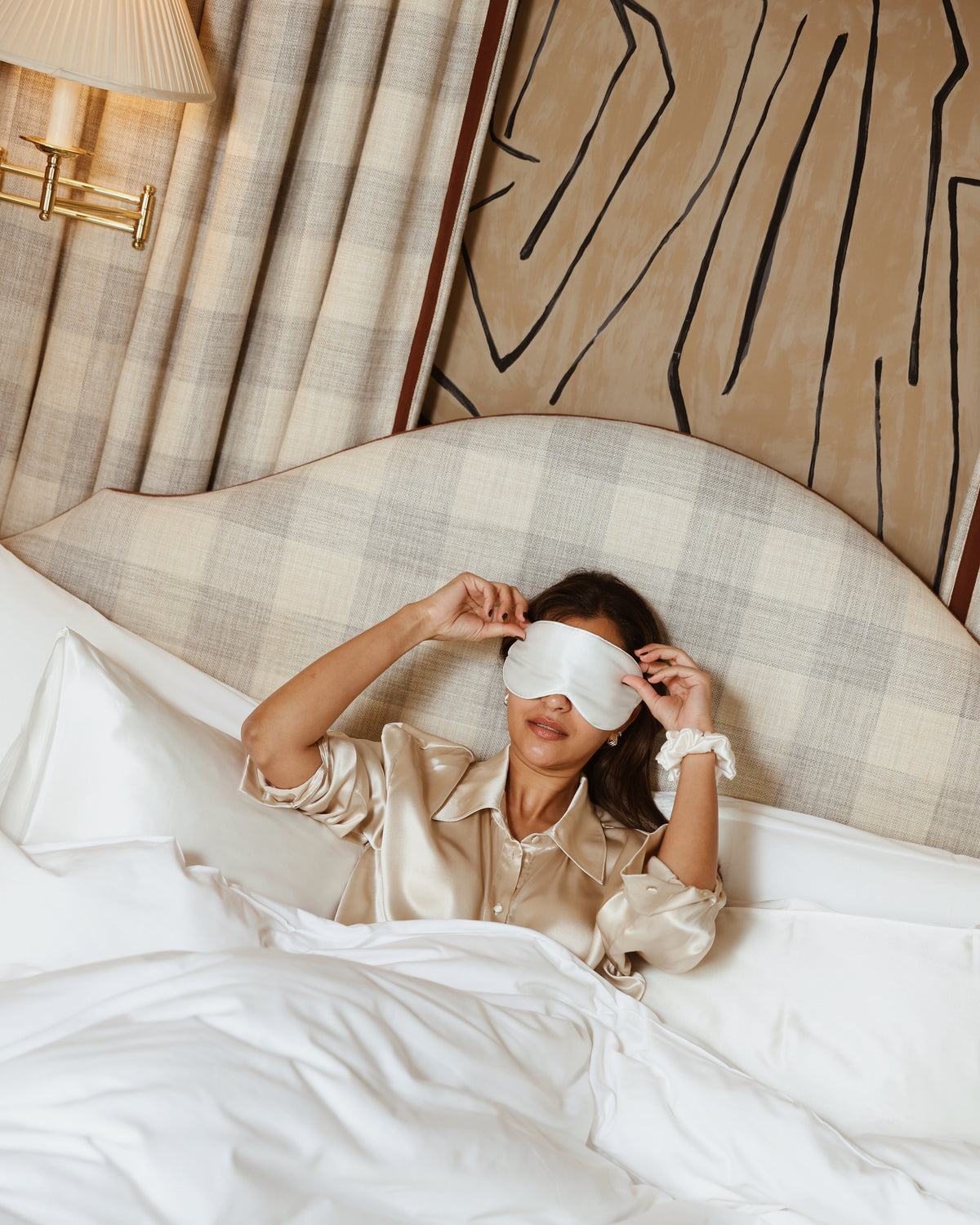 Pearl white silk eye mask putting on in bed